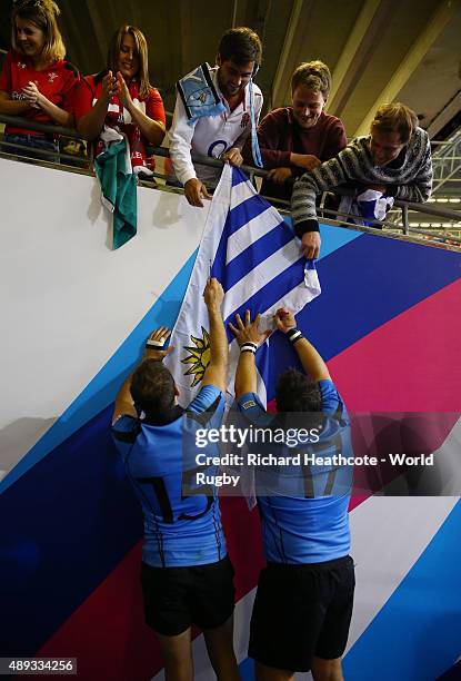 Gaston Mieres of Uruguay and Oscar Duran of Uruguay sign a fans flag during the 2015 Rugby World Cup Pool A match between Wales and Uruguay at the...