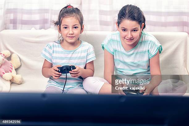 deux petites filles jouant à des jeux vidéo - command sisters photos et images de collection