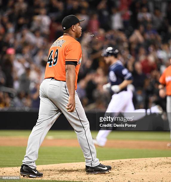 Carlos Marmol of the Miami Marlins walks back to the mound as Chase Headley of the San Diego Padres rounds the bases after hitting a three-run home...