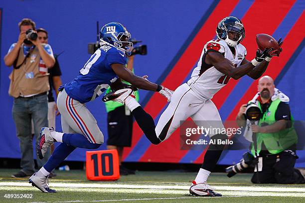 Julio Jones of the Atlanta Falcons completes a first down reception in the fourth quarter under pressure from Prince Amukamara of the New York Giants...