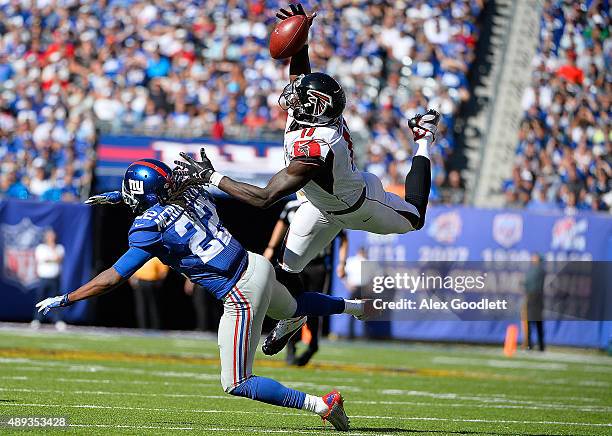 Julio Jones of the Atlanta Falcons makes a first down reception in the fourth quarter under pressure from Brandon Meriweather of the New York Giants...