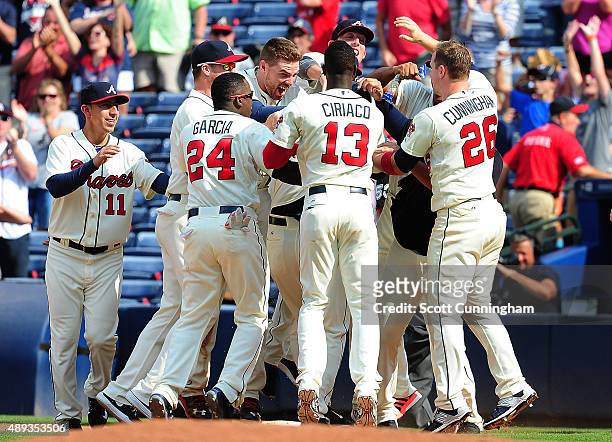 Pierzynski of the Atlanta Braves is mobbed by teammates after knocking in the game-winning run with a ninth inning single against the Philadelphia...
