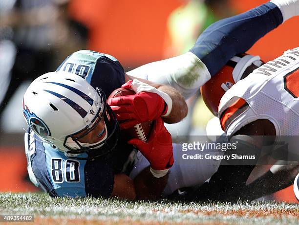 Anthony Fasano of the Tennessee Titans catches a third quarter touchdown next to Donte Whitner of the Cleveland Browns at FirstEnergy Stadium on...