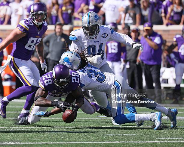 Adrian Peterson of the Minnesota Vikings fumbles the ball after being hit by Rashean Mathis of the Detroit Lions at TCF Bank Stadium on September 20,...