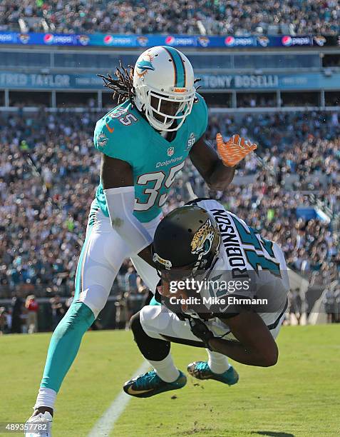 Allen Robinson of the Jacksonville Jaguars is tackled by Walt Aikens of the Miami Dolphins during a game at EverBank Field on September 20, 2015 in...