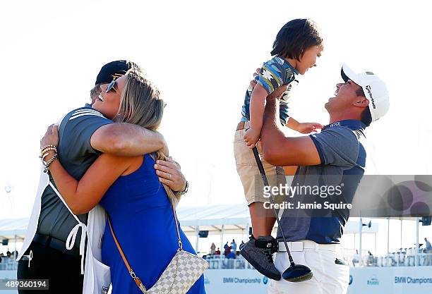 Jason Day of Australia celebrates with his son Dash, wife Ellie and caddie Colin Swatton after winning during the Final Round of the BMW Championship...