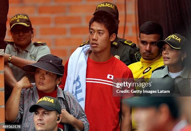 Kei Nishikori watches scorted by police officers during the Davis Cup World Group Play-off singles match between Alejandro Falla of Colombia and Taro...