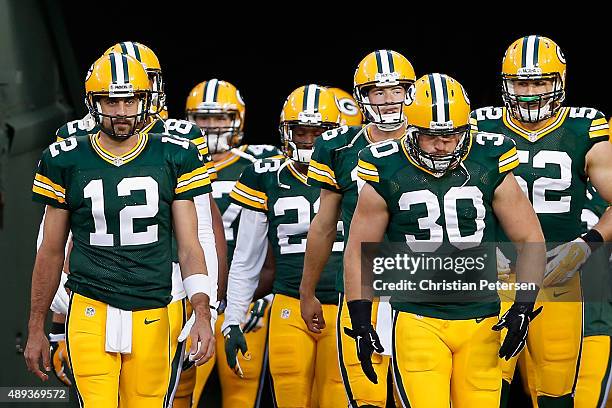 Quarterback Aaron Rodgers and fullback John Kuhn of the Green Bay Packers lead teammates onto the field before the NFL game against the Seattle...