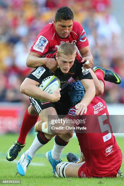 Johnny McNicholl of the Crusaders is tackled by James Horwill and Anthony Faingaa of the Reds during the round 13 Super Rugby match between the Reds...
