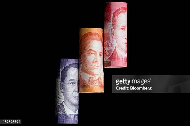 Manuel L. Quezon, left to right, Manuel Acuna Roxas and Sergio Osmena, former presidents of the Philippines, are displayed on one hundred, left to...