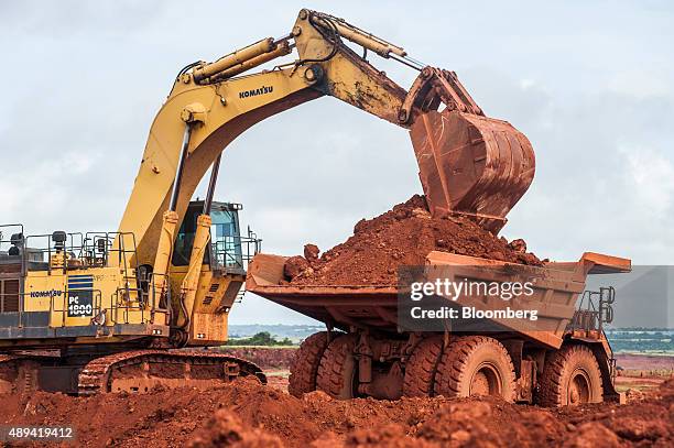 Digger unloads raw bauxite into a truck at the Sangaredi bauxite mine operated by Compagnie des Bauxites de Guinee near Boke, Guinea on Tuesday,...