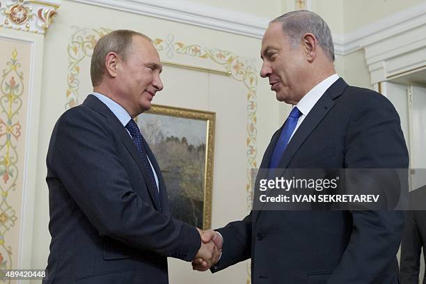 Russian President Vladimir Putin shake hands with Israeli Prime Minister Benjamin Netanyahu during a meeting at the Novo-Ogaryovo residence, outside...