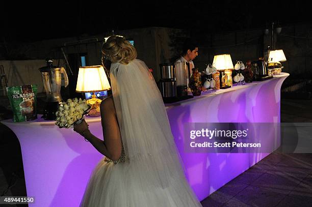 An Iranian bride holds her bouquet at a luxury wedding with mixed dancing and removal of headscarves, at a private garden tailor-made for the purpose...