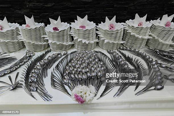 An Iranian table is covered with elaborately laid out cutlery for a luxury wedding with mixed dancing and removal of headscarves, at a private garden...