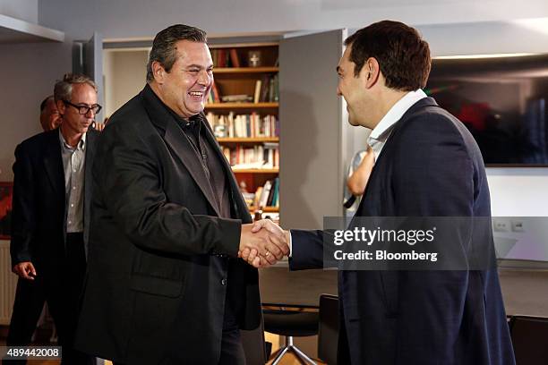 Alexis Tsipras, Greece's incoming prime minister, right, and Panos Kammenos, leader of the Independent Greeks Party, react while shaking hands during...