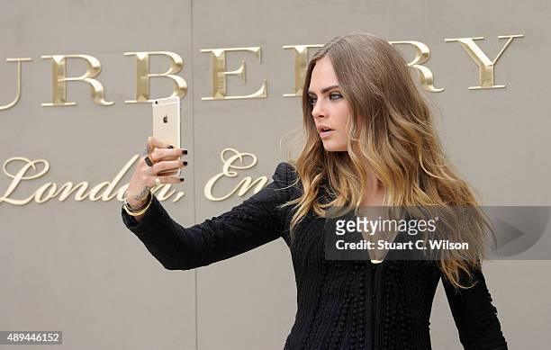 Cara Delevingne attends the Burberry Womenswear Spring/Summer 2016 show during London Fashion Week at Kensington Gardens on September 21, 2015 in...