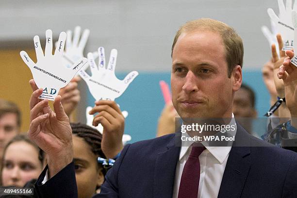 Prince William, Duke Of Cambridge holds a cardboard hand with the names he wrote down of five people he would turn to in the event of bullying, from...