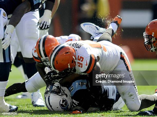 Quarterback Marcus Mariota of the Tennessee Titans is sacked by safety Donte Whitner and defensive end Armonty Bryant of the Cleveland Browns during...