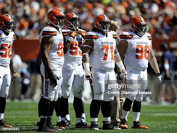 Defensive end Desmond Bryant, defensive end Armonty Bryant, defensive tackle Danny Shelton, and defensive tackle Jamie Meder stand at the line of...