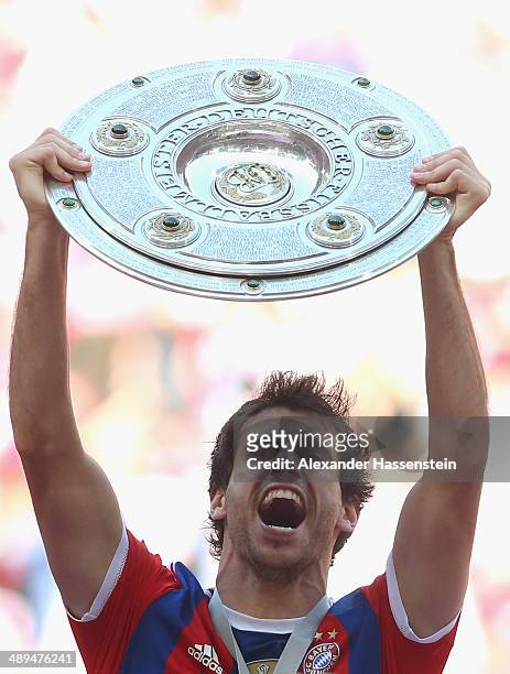 Javier Martinez of Bayern Muenchen lifts the Bundesliga championship trophy in celebration after the Bundesliga match between Bayern Muenchen and VfB...