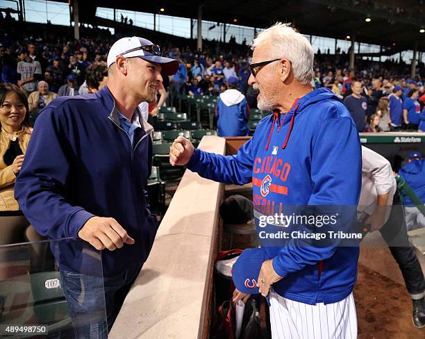 Former Chicago Cubs pitcher Kerry Wood talks with Chicago Cubs manager Joe Maddon before the start of the team's game against the Milwaukee Brewers...