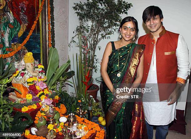 Indian Bollywood actor Vivek Oberoi and his wife pose with a statue of the elephant-headed Hindu god Lord Ganesh to mark the Hindu festival Ganesh...