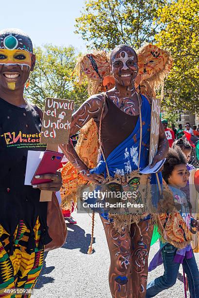 Parade participants march with a tribal themed group wearing colorful face paint. The 46th Annual African-American Day Parade was held in Harlem; the...
