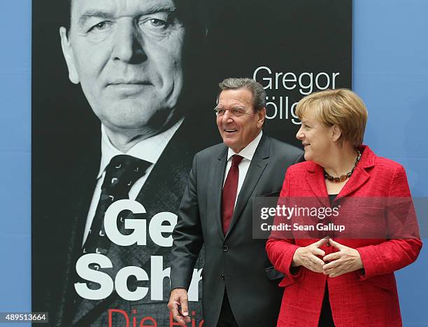 German Chancellor Angela Merkel and former Chancellor Gerhard Schroeder arrive for the presentation of Schroeder's biography on September 22, 2015 in...
