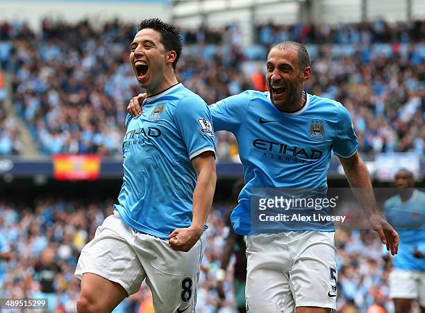 Samir Nasri of Manchester City celebrates scoring the first goal with team-mate Pablo Zabaleta during the Barclays Premier League match between...