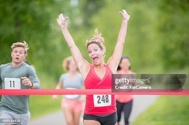 woman winning a race - finish line ribbon stock pictures, royalty-free photos & images