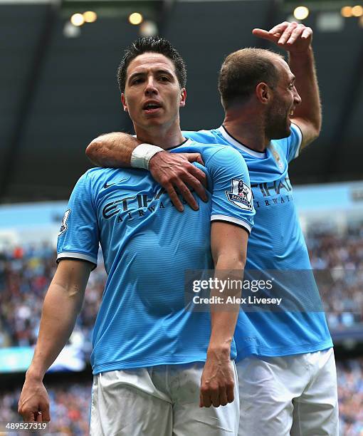 Samir Nasri of Manchester City celebrates scoring the first goal with team-mate Pablo Zabaleta during the Barclays Premier League match between...