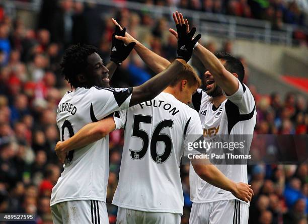 Wilfried Bony of Swansea City celebrates with Jay Fulton and Jordi Amat as he scores their third goal during the Barclays Premier League match...