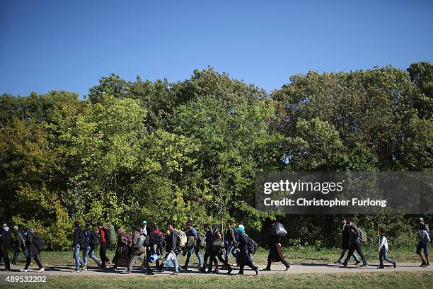 Hundreds of migrants who arrived by train at Hegyeshalom on the Hungarian and Austrian border walk the four kilometres into Austria on September 22,...