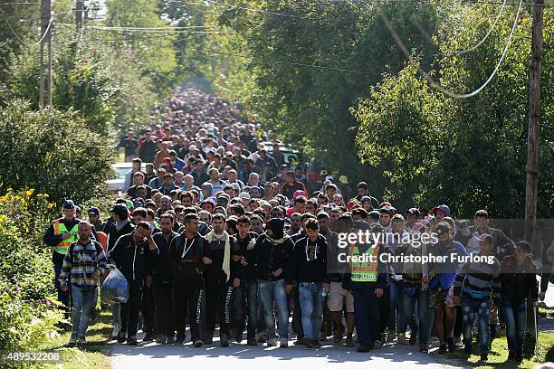 Hundreds of migrants who arrived by train at Hegyeshalom on the Hungarian and Austrian border walk the four kilometres into Austria on September 22,...