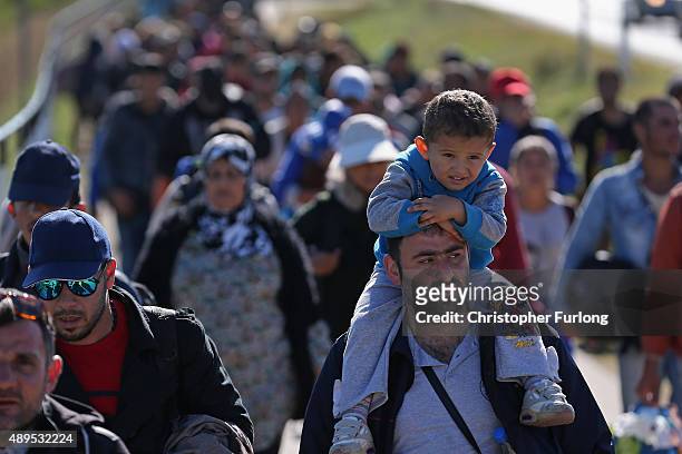 Hundreds of migrants who arrived by train at Hegyeshalom on the Hungarian and Austrian border walk the four kilometres into Austria on September 22,...