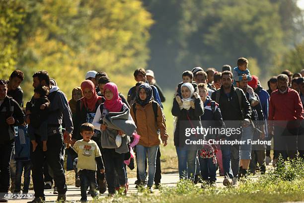 Hundreds of migrants who arrived by train at Hegyeshalom on the Hungarian and Austrian border walk the four kilometres into Austria on September 22,...