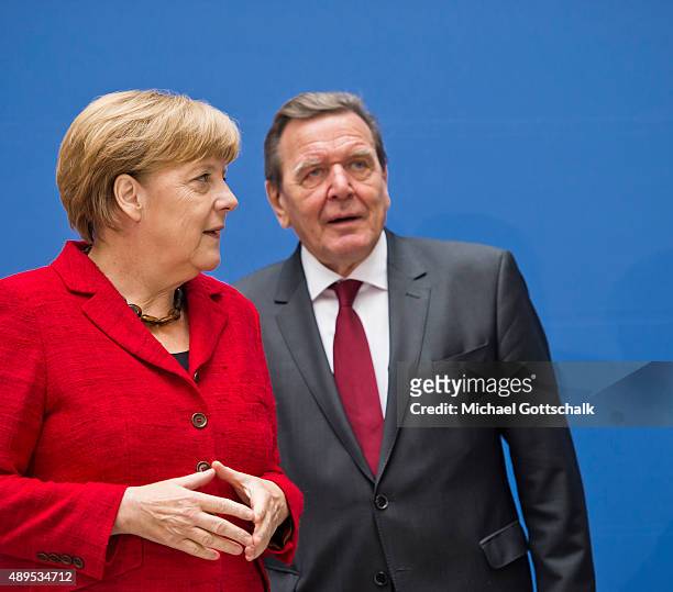 Former German Chancellor Gerhard Schroeder and German Chancellor Angela Merkel attends the presenation of 'Die Biographie' of 'The Biography' by...