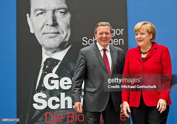 Former German Chancellor Gerhard Schroeder and German Chancellor Angela Merkel attends the presenation of 'Die Biographie' of 'The Biography' by...