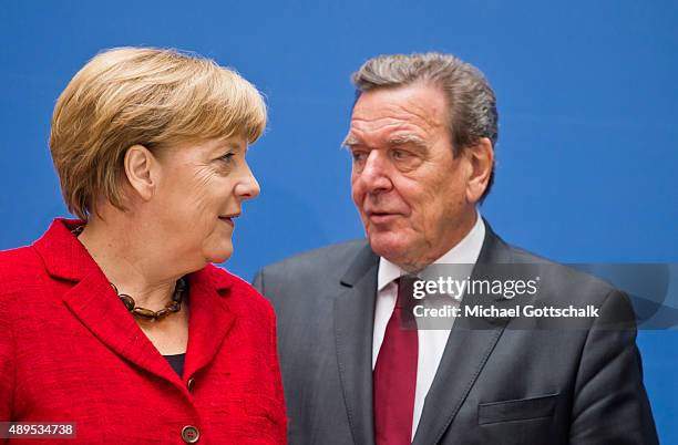 Former German Chancellor Gerhard Schroeder and German Chancellor Angela Merkel attends the presenation of 'Die Biographie' of 'The Biography' by...