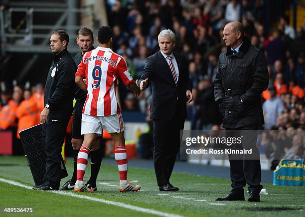 Mark Hughes manager of Stoke City shakes hands with Peter Odemwingie of Stoke City as Pepe Mel manager of West Bromwich Albion looks on during the...