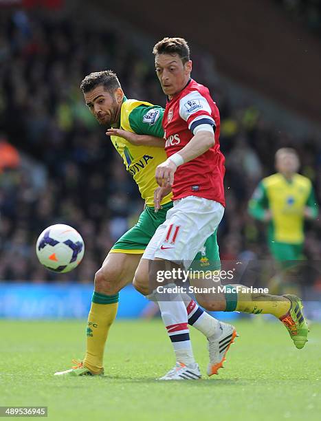 Mesut Ozil of Arsenal challenged by Robert Snodgrass of Norwich during the Barclays Premier League match between Norwich City and Arsenal at Carrow...