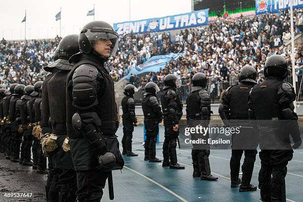 Supporters of FC Zenit St. Petersburg are seen in the stands along with a riot policemen in the foreground during the Russian Football League...