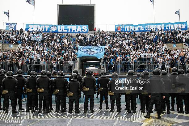 Supporters of FC Zenit St. Petersburg are seen in the stands along with a riot policemen in the foreground during the Russian Football League...