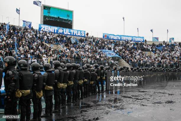 Supporters of FC Zenit St. Petersburg are seen in the stands along with a riot policemen in the foreground during the Russian Football League...