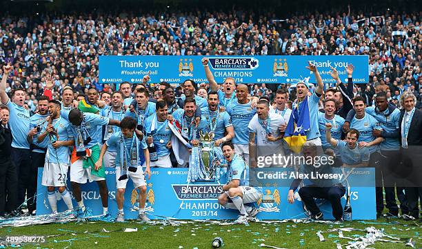 The Manchester City players celebrate with the Premier League trophy at the end of the Barclays Premier League match between Manchester City and West...