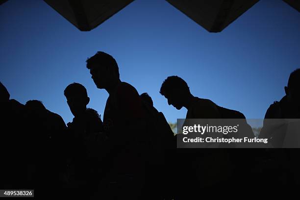 Migrants who arrived on the second train today at Hegyeshalom on the Hungarian and Austrian border, queue for food as they walk the four kilometres...