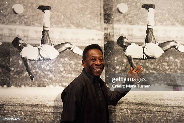 Pele poses in front of Russell Young - Bicycle Kick as he launches Art, Life, Football at Halcyon Gallery on September 22, 2015 in London, England.