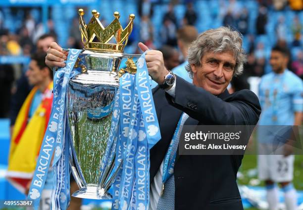 The Manchester City Manager Manuel Pellegrini poses with the Premier League trophy at the end of the Barclays Premier League match between Manchester...