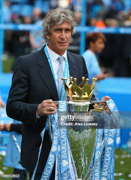 The Manchester City Manager Manuel Pellegrini poses with the Premier League trophy at the end of the Barclays Premier League match between Manchester...