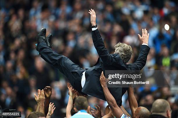 The Manchester City Manager Manuel Pellegrini is thrown in the air by his players at the end of the Barclays Premier League match between Manchester...